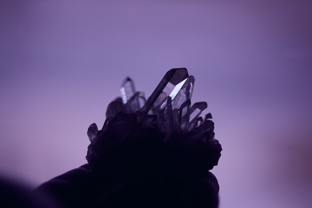 Still life of a natural quartz crystal cluster with purple background.